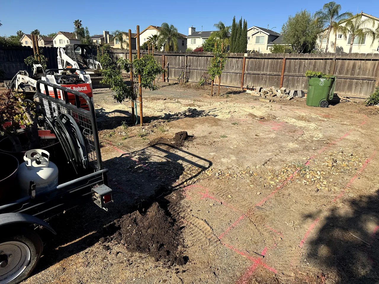 Grading the backyard with a skid steer before the patio and sod go in
