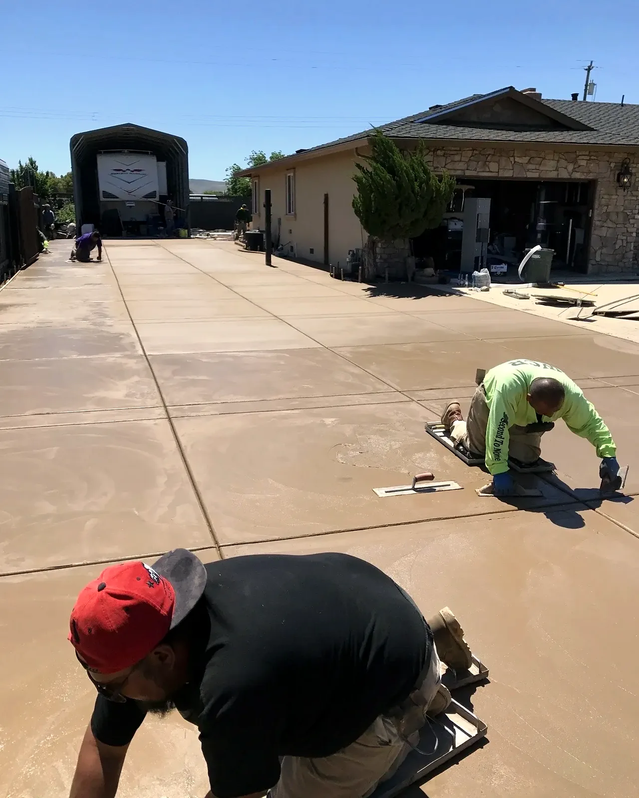 The colored concrete driveway, poured and being finished by the crew