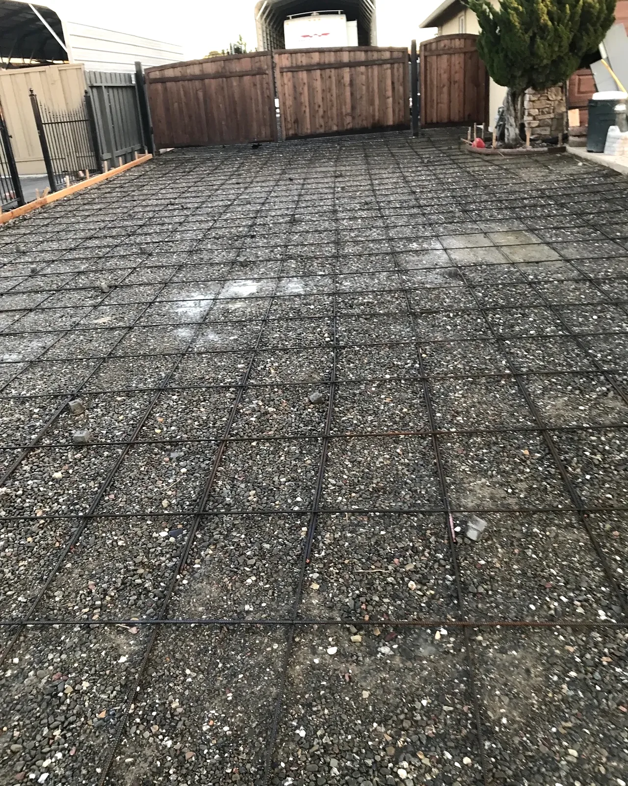 An old gravel lot held by a plastic grid, before the concrete driveway